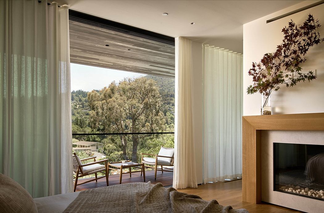 Bright, open living space with expansive windows, modern fireplace, and natural-themed decor.