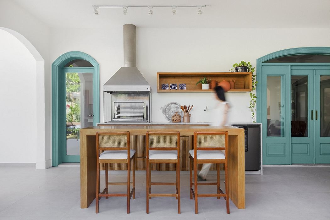 Modern kitchen with wooden island, arched turquoise doors, and minimalist decor.