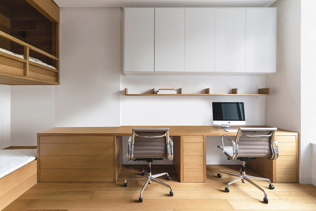 Sleek, minimalist home office with wooden cabinetry, shelves, and desk space.