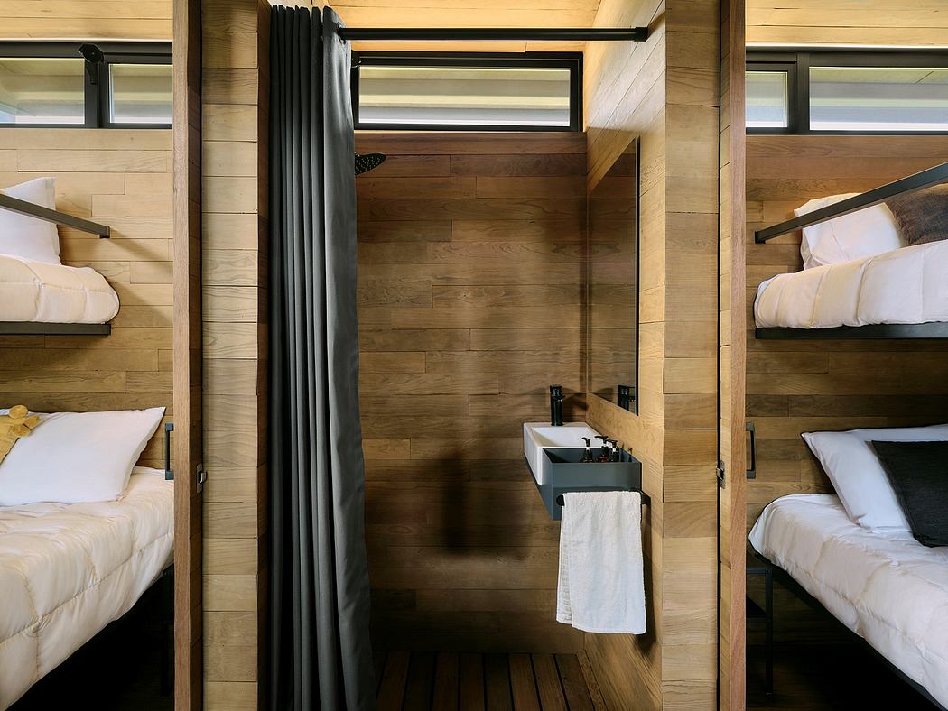 Cozy cabin-inspired bedroom with wood-paneled walls, bunk beds, and an ensuite bathroom.