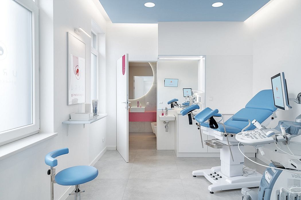 A modern, well-lit medical examination room with sleek, blue-accented furniture and equipment.