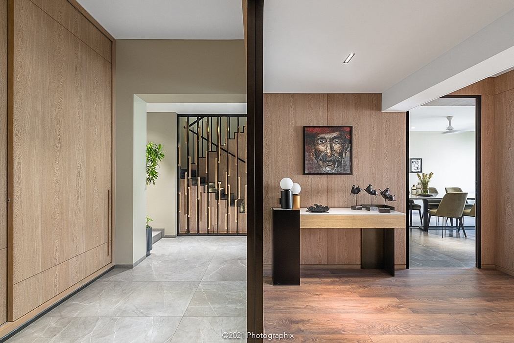Elegant foyer with wooden paneling, artwork, and an intriguing metal staircase design.