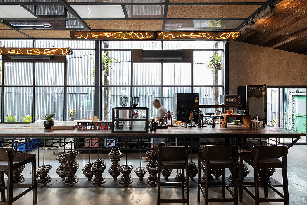 Modern industrial-style café with wooden beams, metal frames, and eclectic furnishings.
