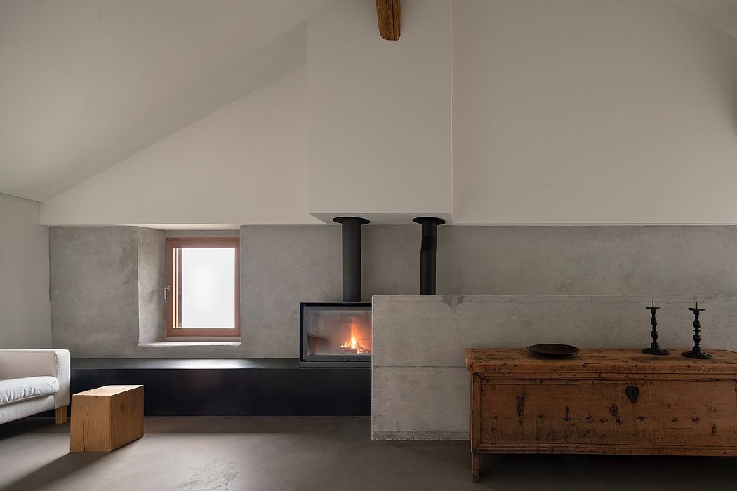 Minimalist living room with concrete fireplace, wooden furniture, and window.