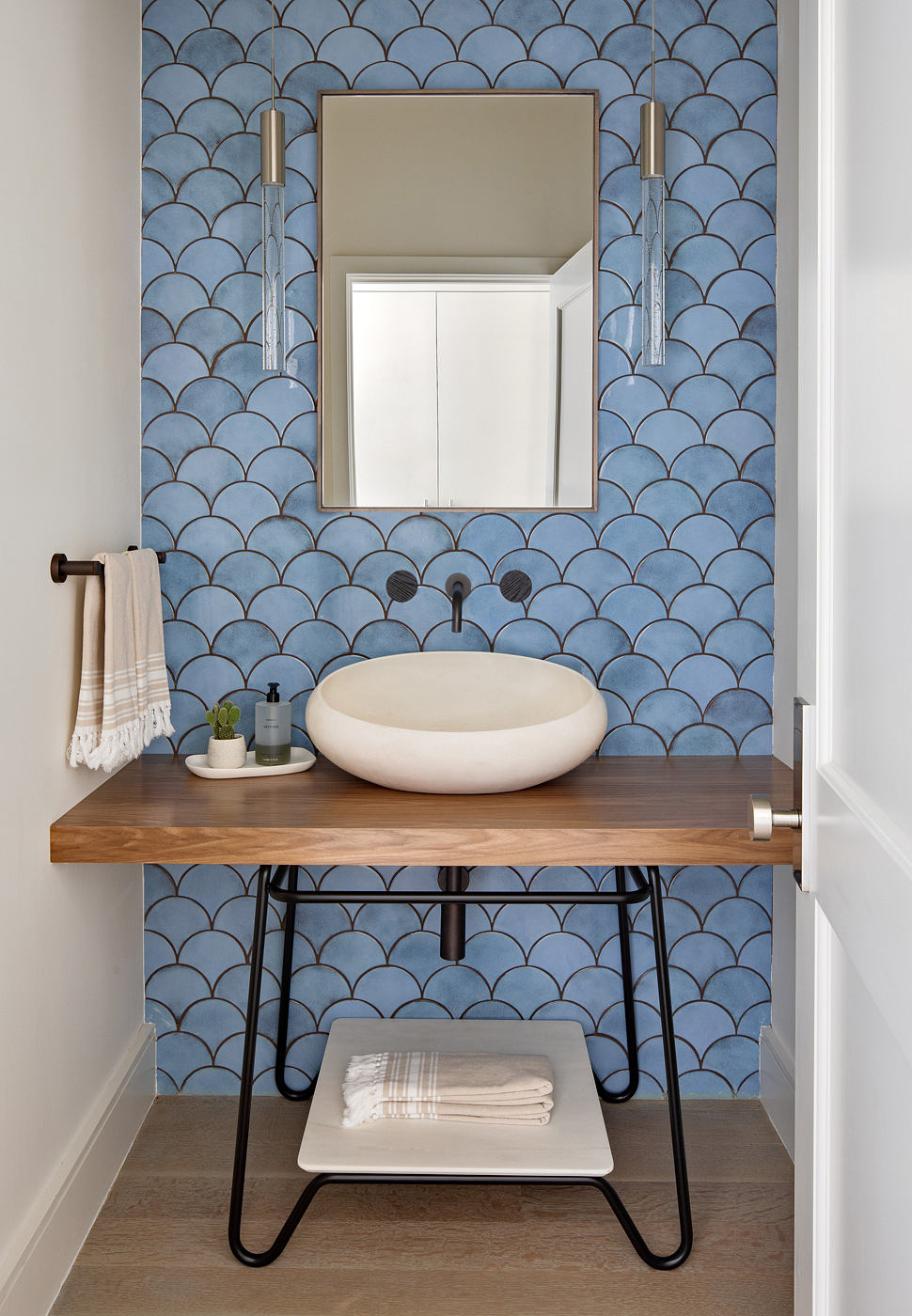 Stylish bathroom with patterned blue tiles, wooden vanity, and contemporary fixtures.