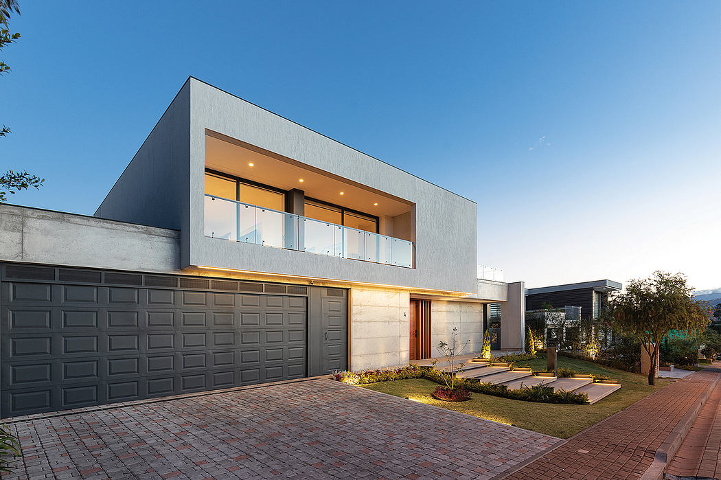 Modern, minimalist house with clean lines, large windows, and a landscaped front yard.