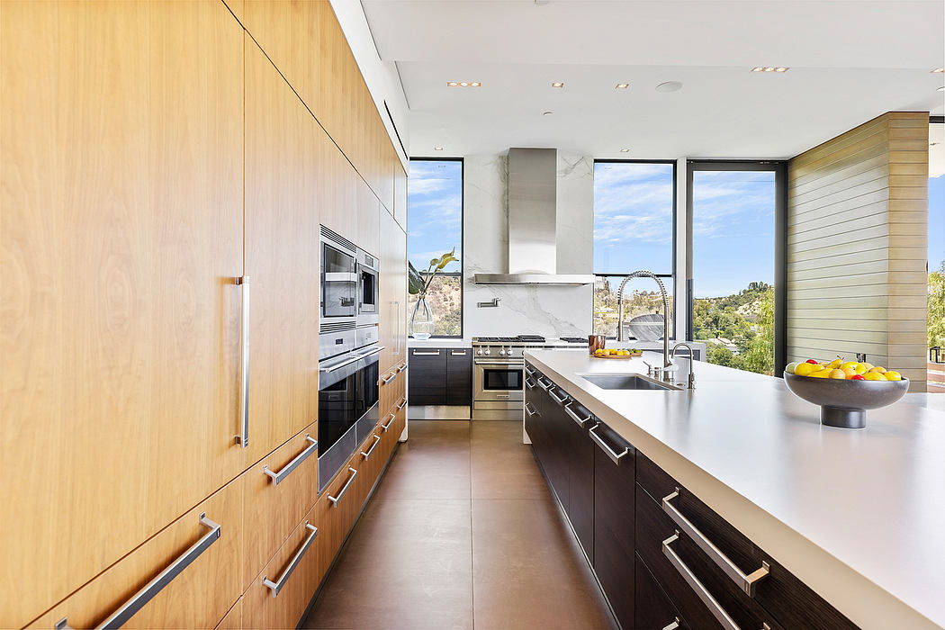 A sleek, modern kitchen with wood cabinetry, stainless steel appliances, and panoramic views.