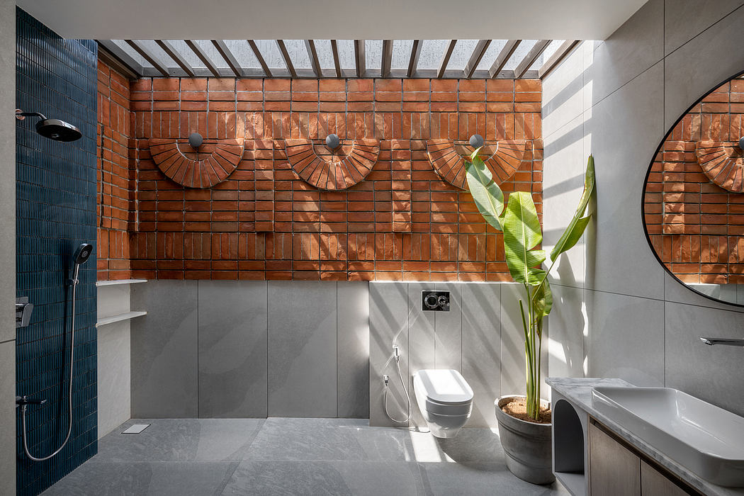 The image showcases a modern bathroom design featuring exposed brick walls, skylights, and a potted plant.