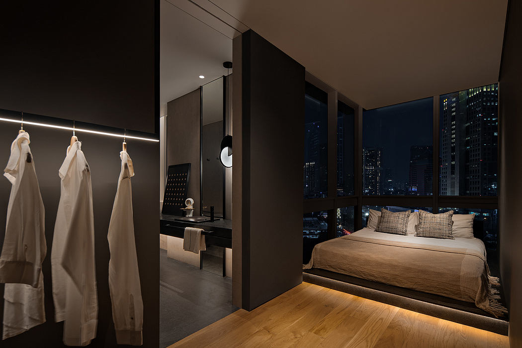 Luxurious contemporary bedroom with floor-to-ceiling windows, modern furniture, and indirect lighting.