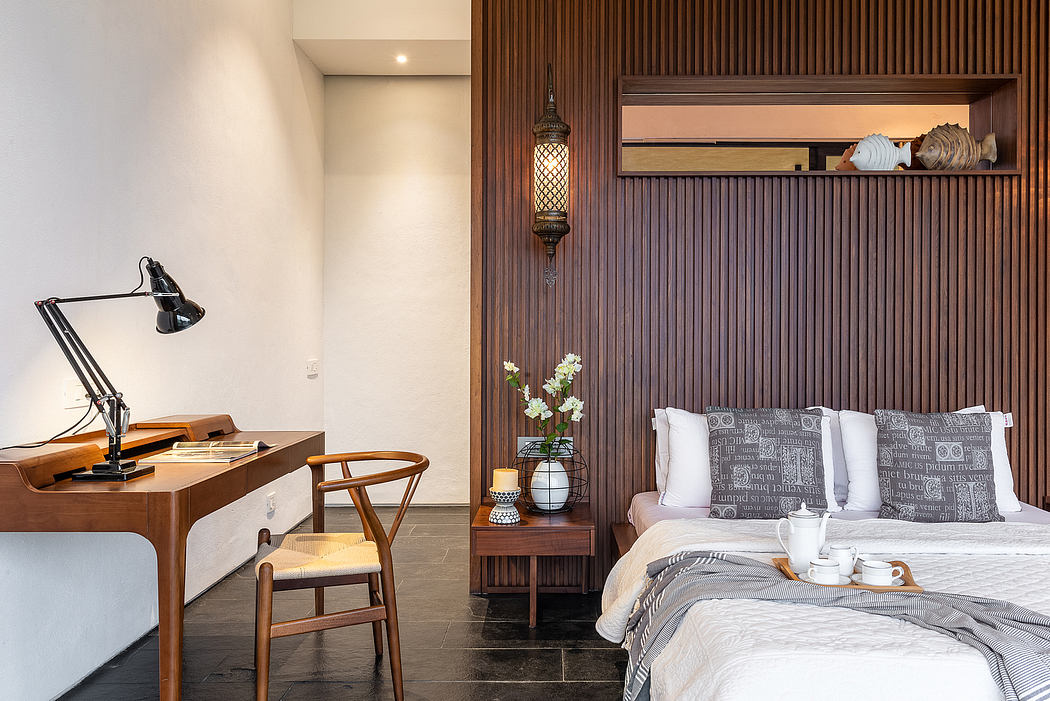 Cozy bedroom with wooden paneling, desk, and pendant lamp exuding warm, modern ambiance.