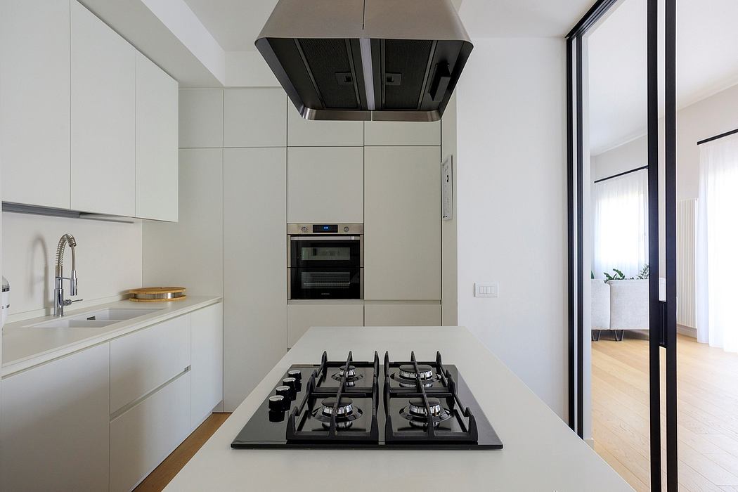 Modern kitchen with white cabinetry, stainless steel appliances, and a built-in oven.