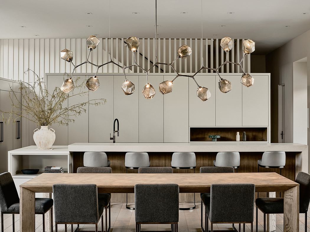 Sleek, modern kitchen with geometric pendant lighting and minimalist dining table.
