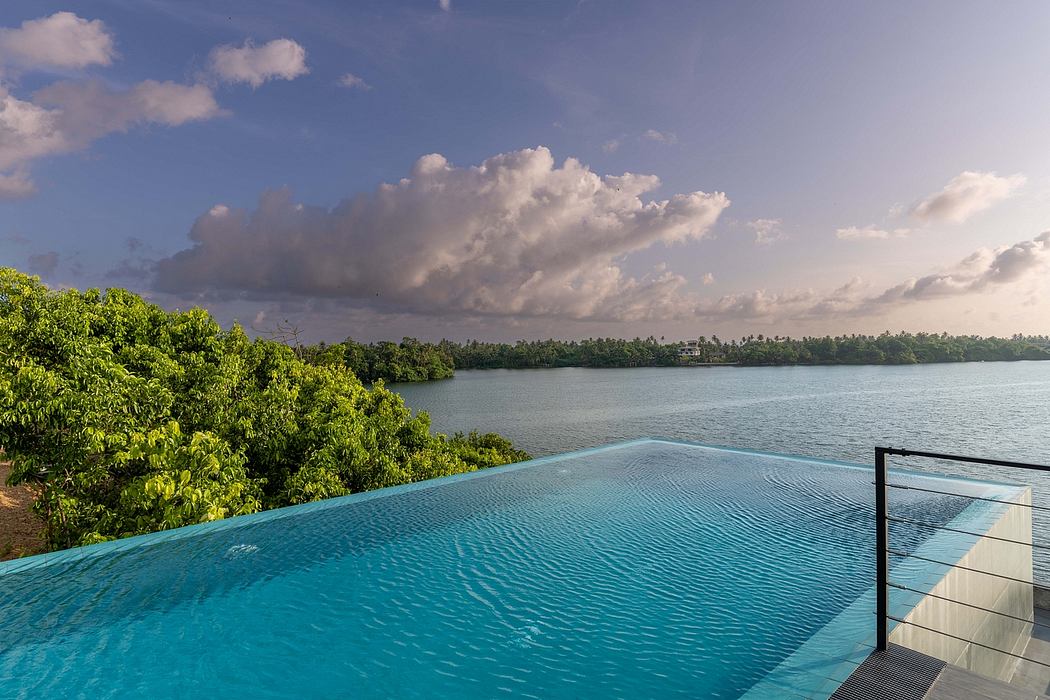 Infinity pool overlooking tropical greenery and a body of water on the horizon.