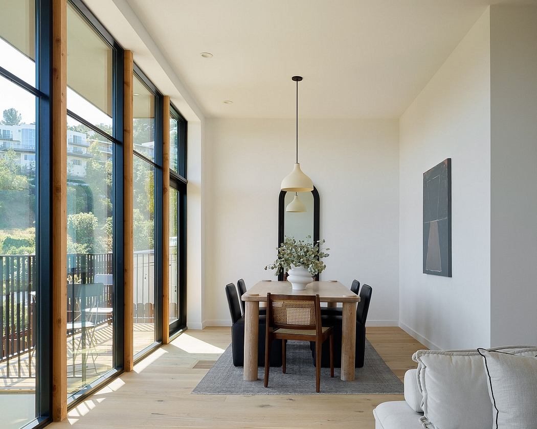 Spacious dining area with large windows, wooden dining table, and modern pendant lighting.