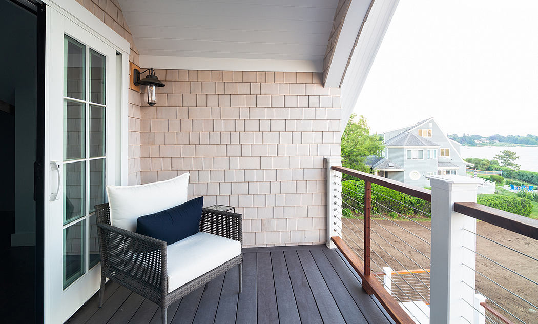 Cozy porch with wooden planks, rattan chair, and tiled exterior walls overlooking greenery.