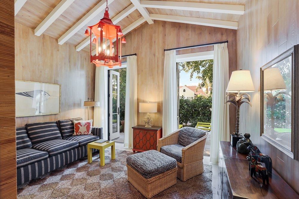 Cozy, rustic interior with wooden beams, plush furnishings, and vibrant lighting fixtures.