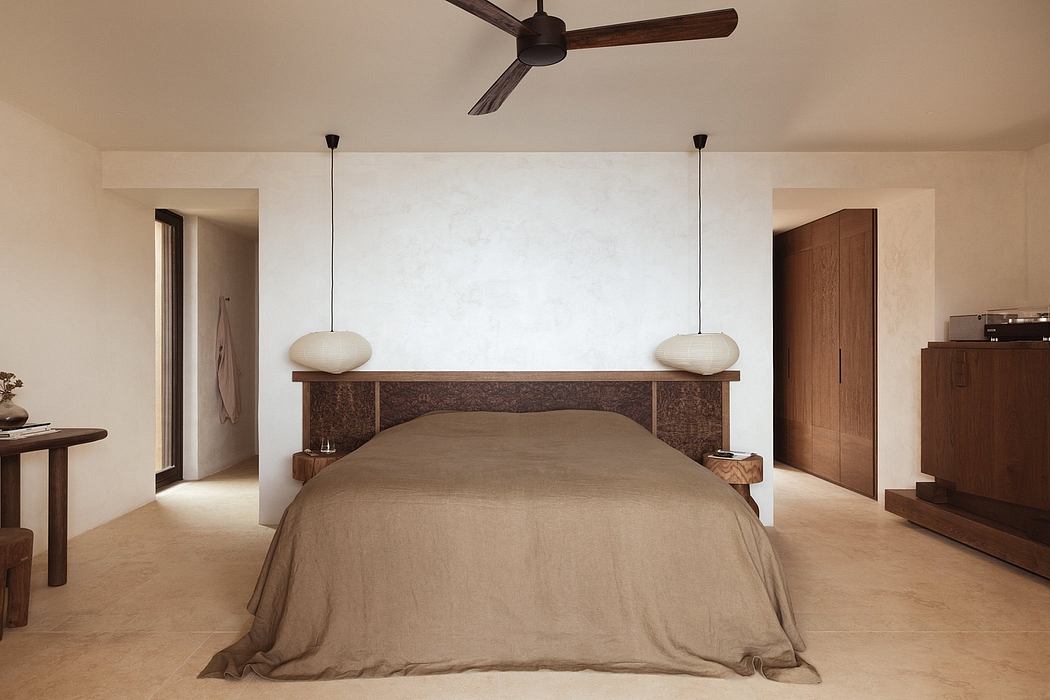 Minimalist bedroom with a large wooden bed, suspended lamps, and a sleek, modern design.