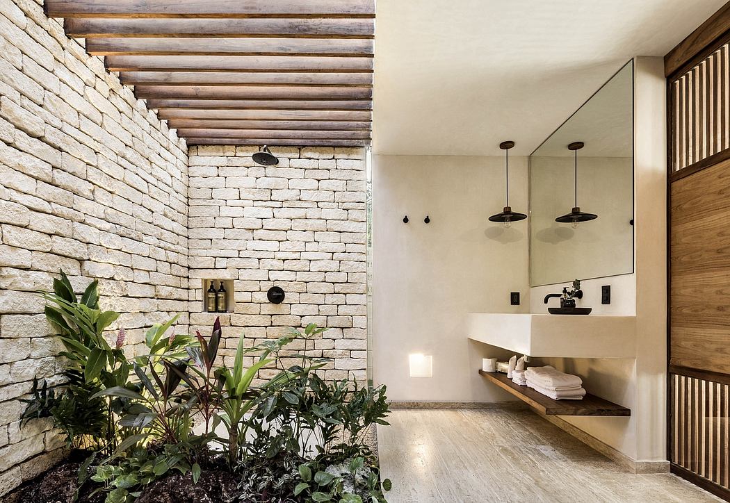 Indoor space with exposed stone walls, wooden beams, and an accent of potted plants.