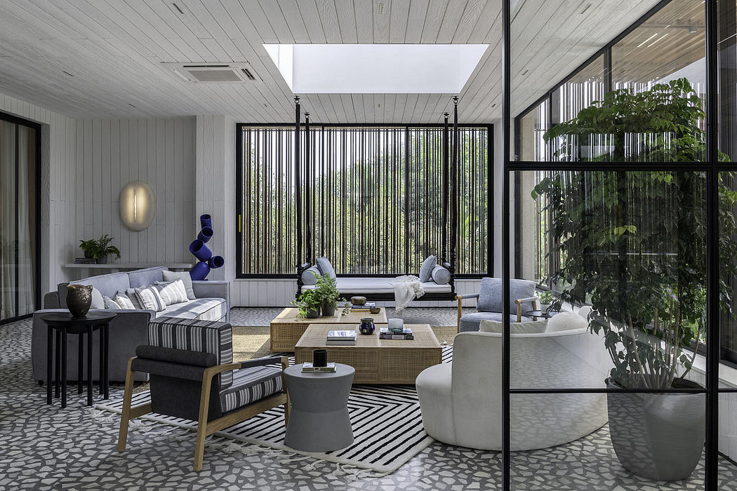 Modern living room with sleek furnishings, large windows, and ornamental plants.