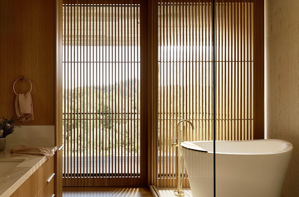 A modern bathroom with wooden slatted screens, a freestanding bathtub, and minimalist decor.