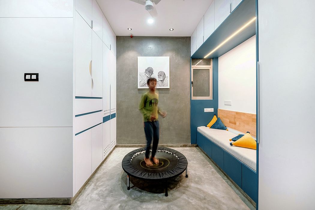 Modern, minimalist apartment interior with a trampoline-like exercise device and artwork.