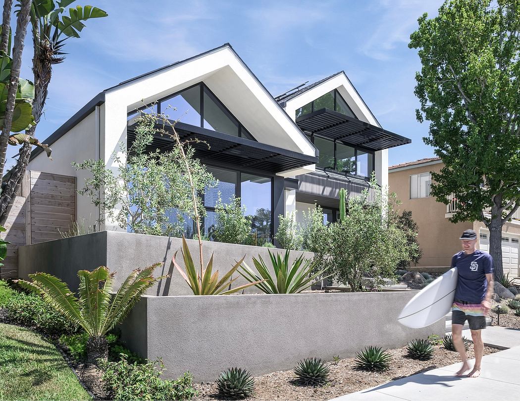 A contemporary residence with sharp angular rooflines, contrasting textures, and lush landscaping.
