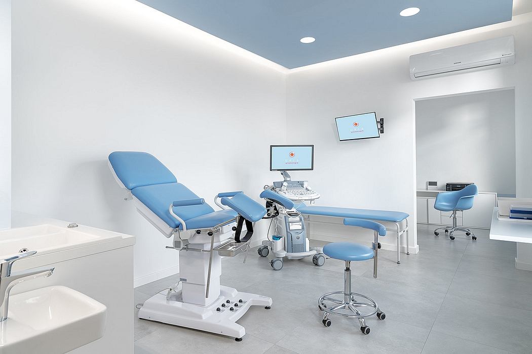 Sleek, modern medical examination room with adjustable examination table, computers, and lighting.