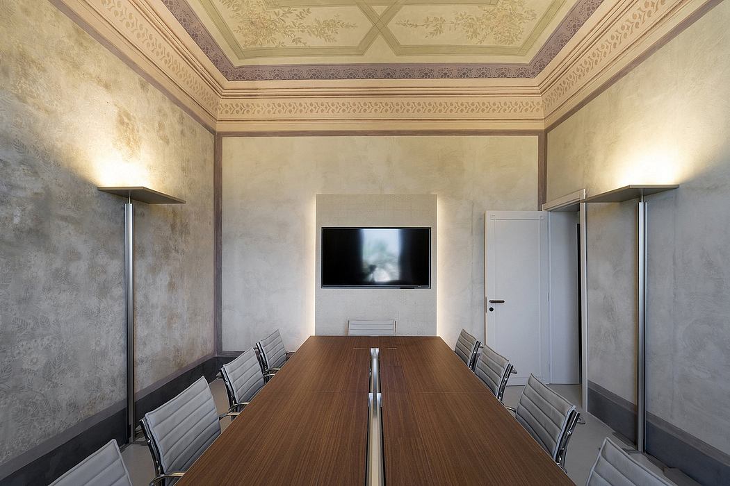 A grand, ornately decorated meeting room with a large wooden table and plush chairs.