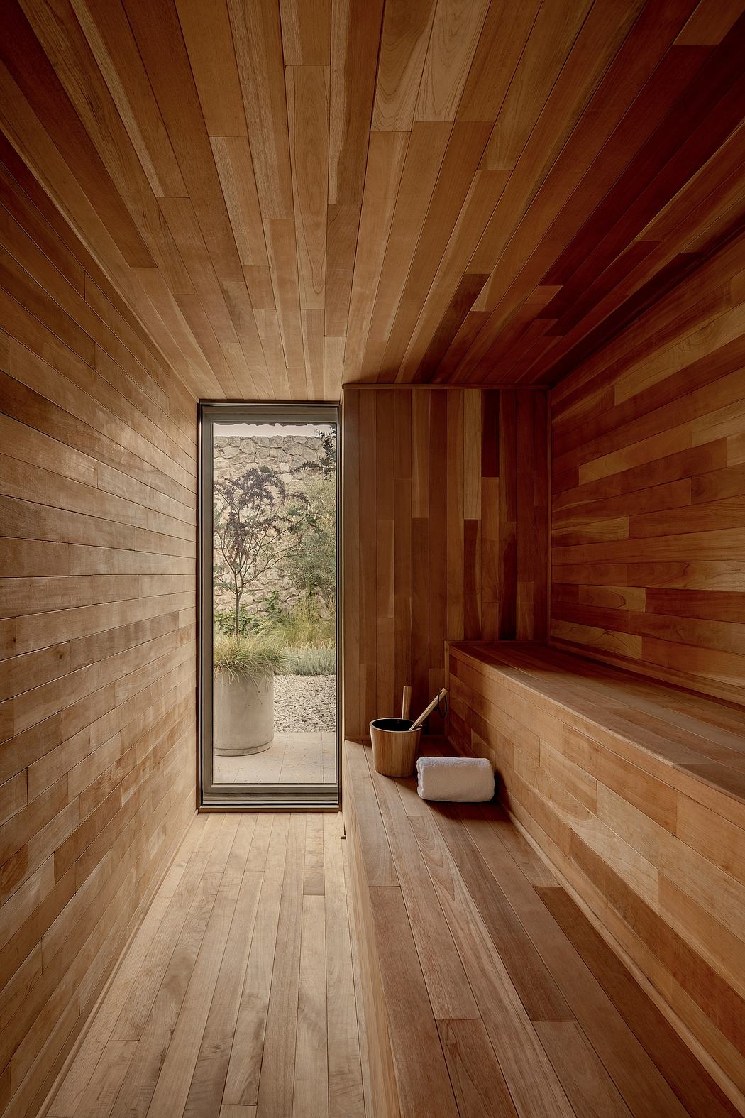 A cozy wooden interior with a narrow entryway and a view of the outdoors.