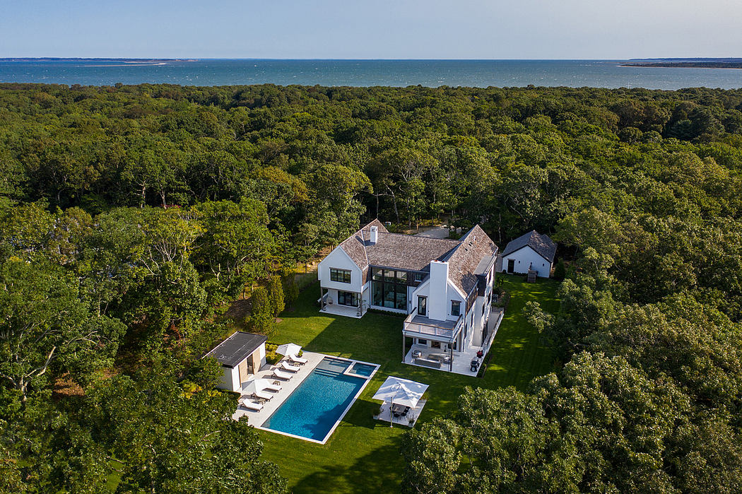 Coastal estate nestled in lush greenery, featuring modern architecture, pool, and decks.