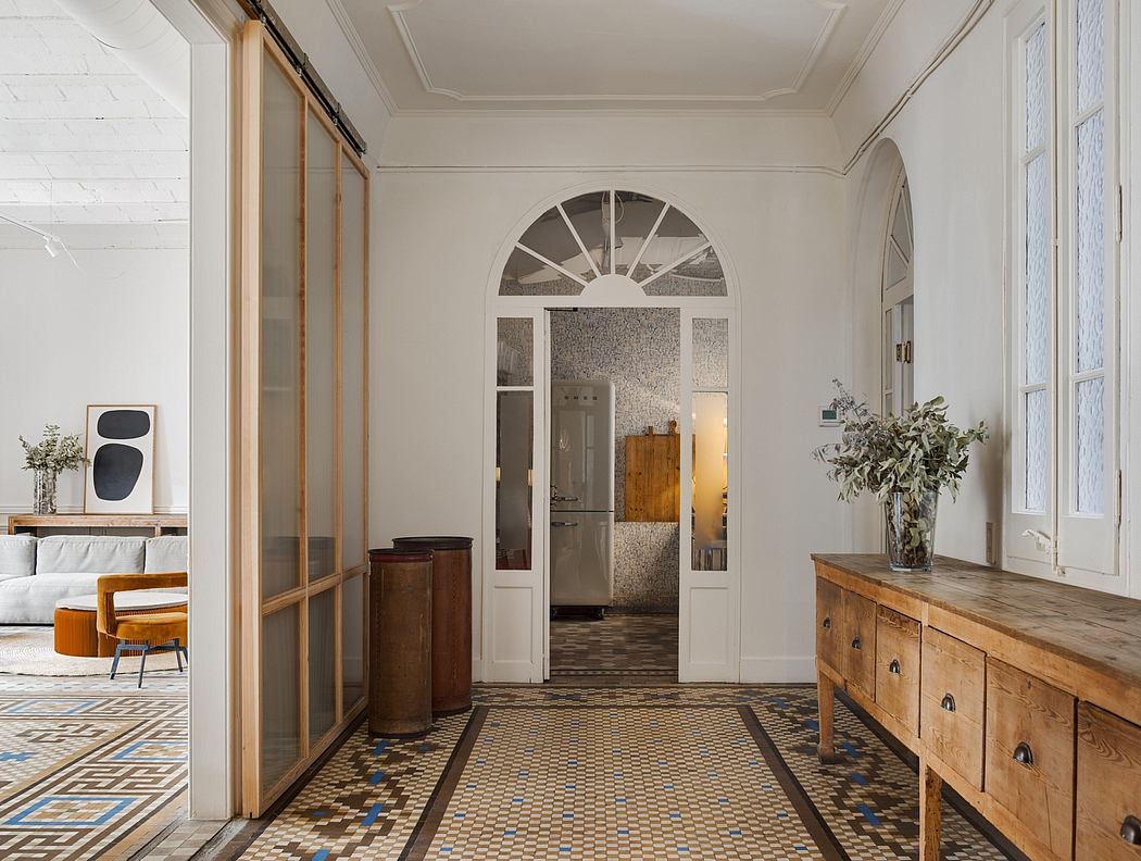 A spacious entryway with decorative archways, wooden cabinetry, and tiled flooring.