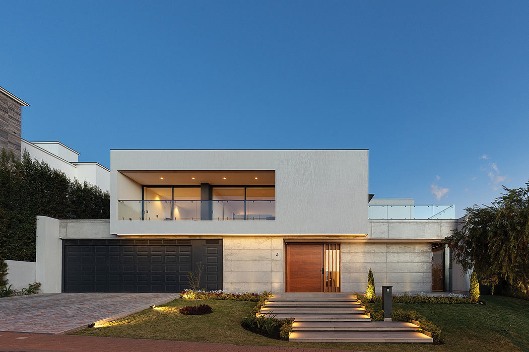 Modern, minimalist house with clean lines, large windows, and a wooden accent on the entrance.
