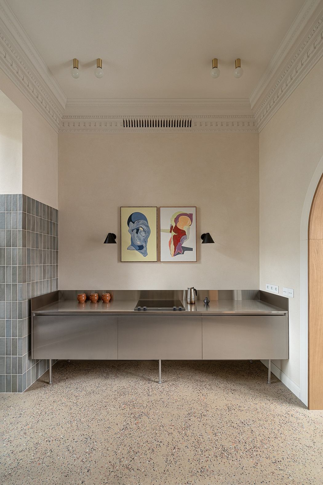 A modern kitchen with minimal cabinetry, sleek countertops, and abstract art wall decor.