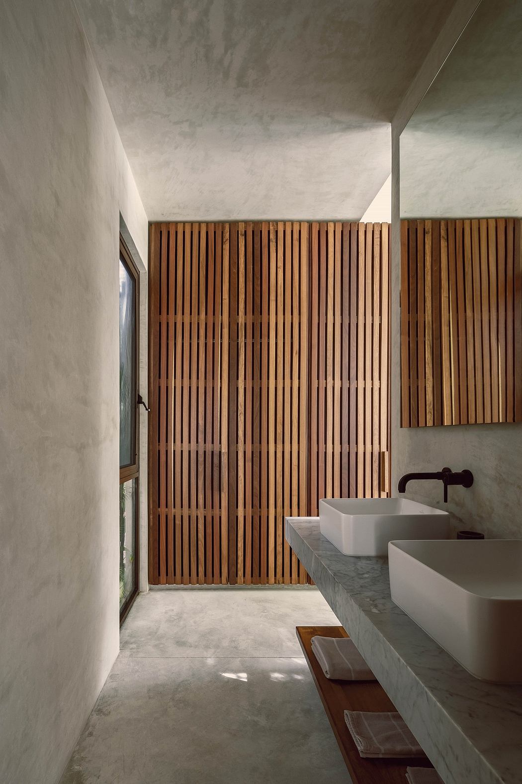 Minimalist bathroom with wooden slat wall and concrete vanity complementing the space.
