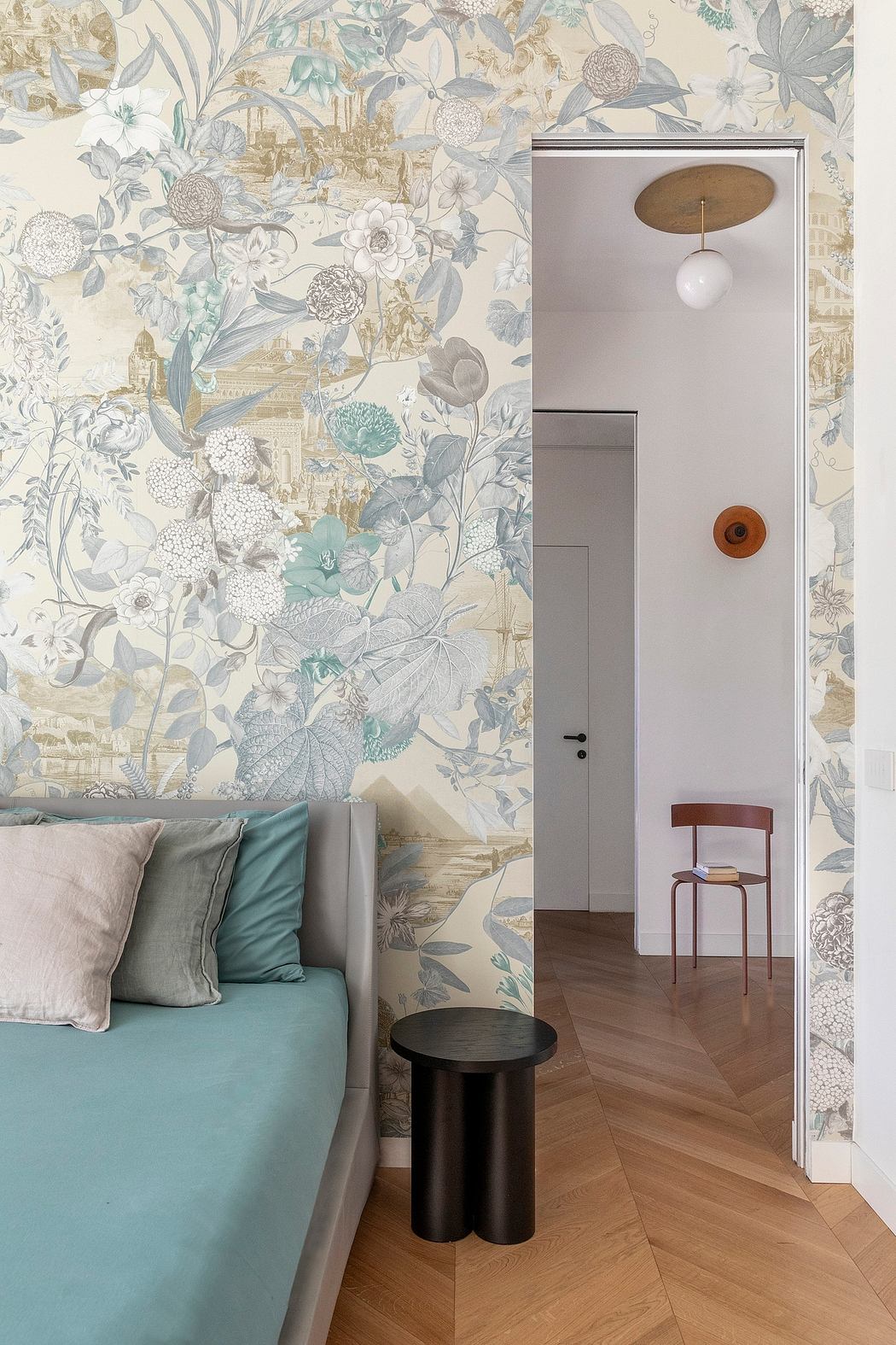 Elegant floral wallpaper, soft teal sofa, and sleek wooden furniture in a cozy interior.