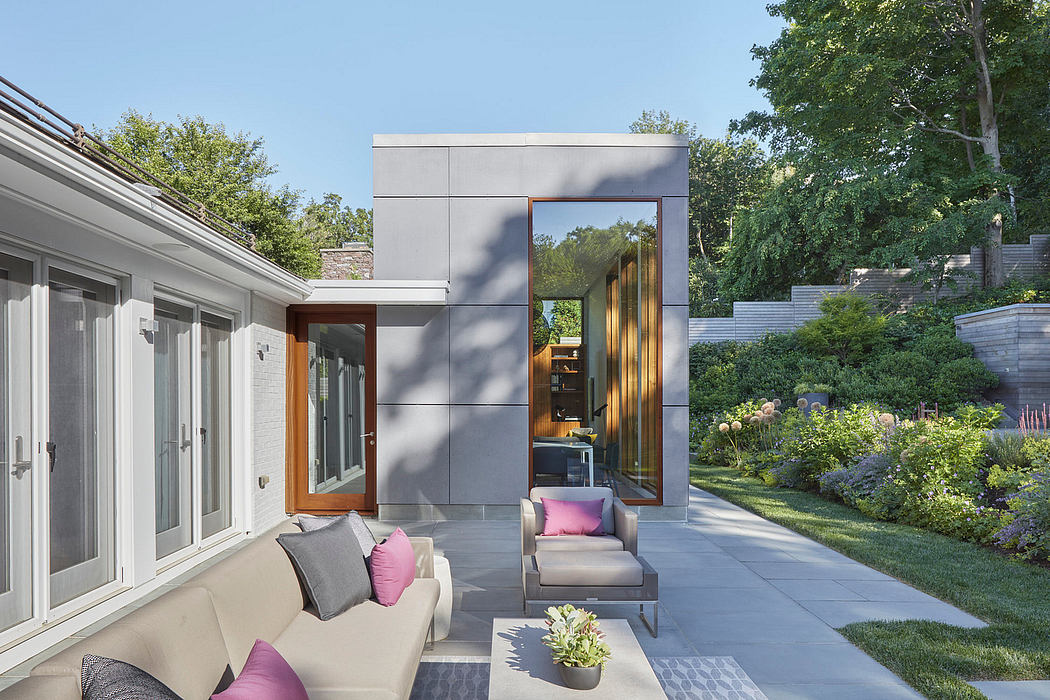 Sleek, modern exterior with wood accents, expansive glass doors, and lush greenery.