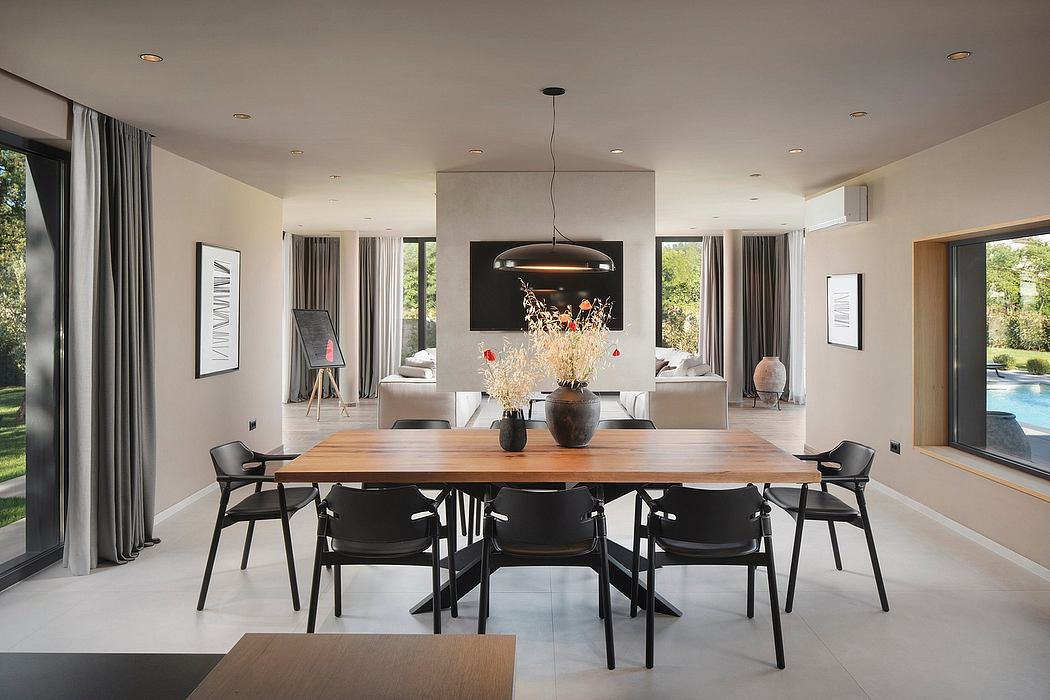 Elegant, open-concept dining room with wood table, black chairs, and modern lighting.
