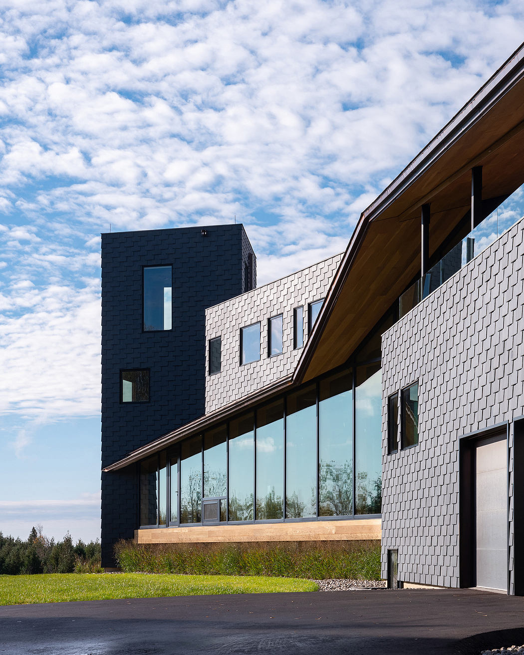 Striking architectural design with varied textures, angles, and large windows overlooking nature.