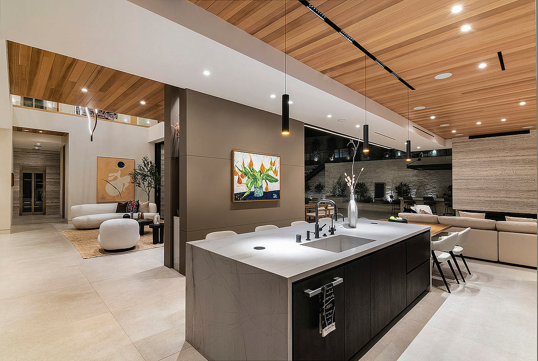 Sleek, modern kitchen with wood-paneled ceiling, gray cabinetry, and abstract art.