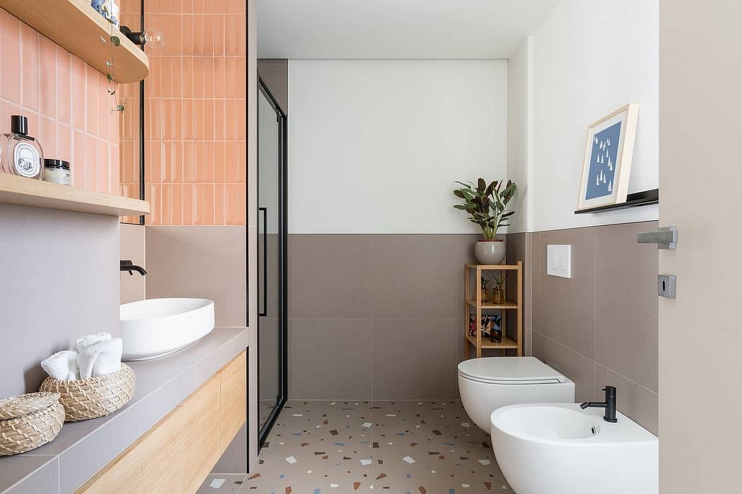 Minimalist bathroom design with pink and gray tiles, wooden vanity, and decorative accents.