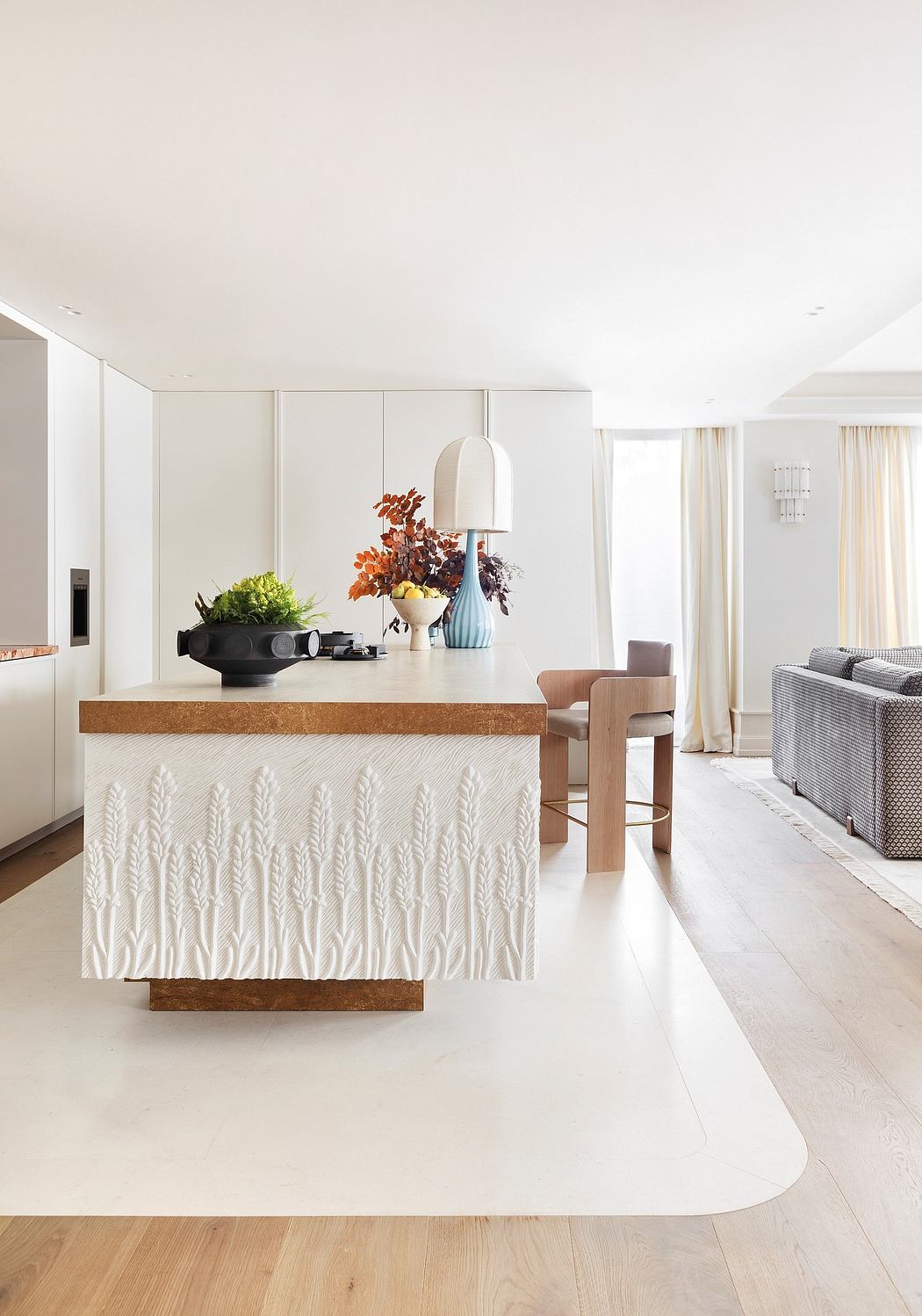 A modern, open-concept kitchen with a textured, wooden counter and decorative vases.