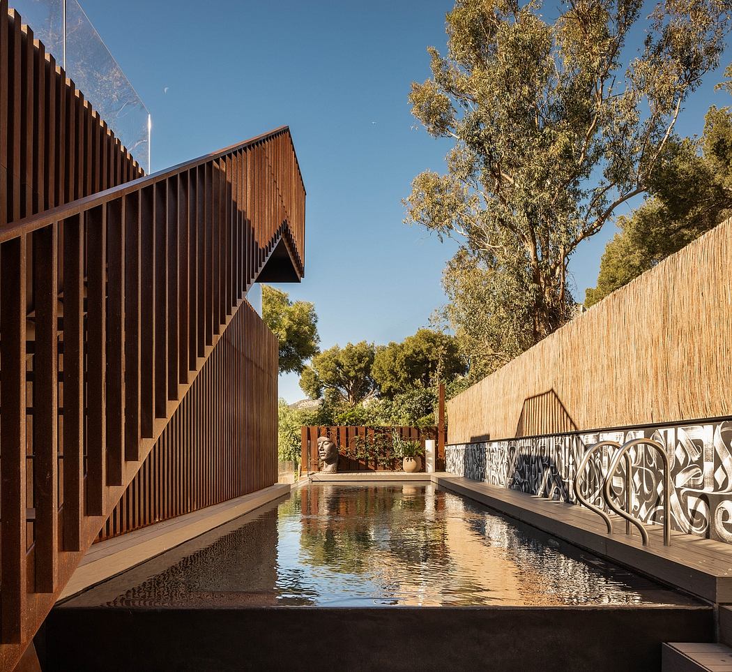 A serene reflecting pool surrounded by an intricate wooden structure, framing lush greenery.