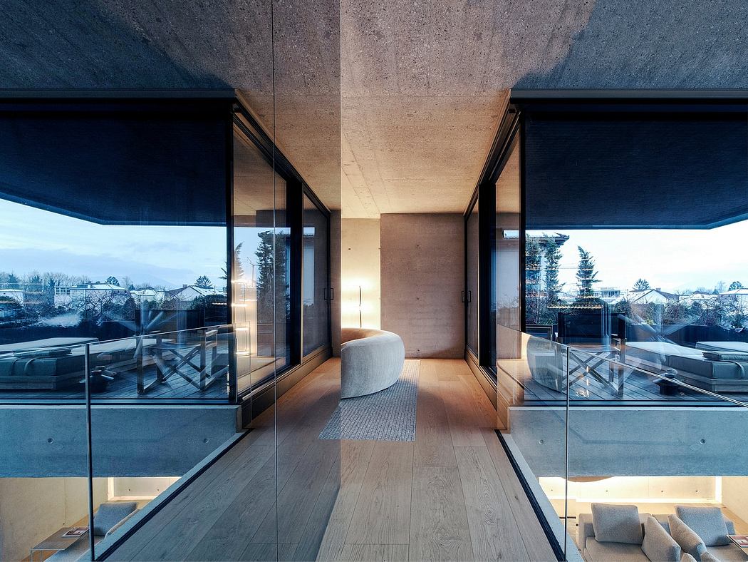 Modernist interior with expansive windows, concrete walls, and minimalist furniture.