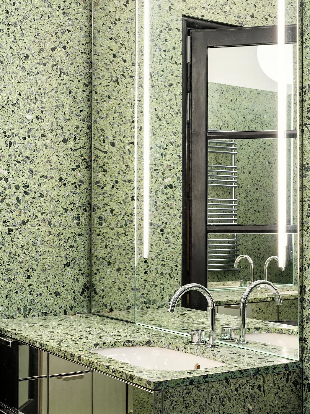 Modern vanity with terrazzo-style countertop, chrome faucets, and full-length mirror.