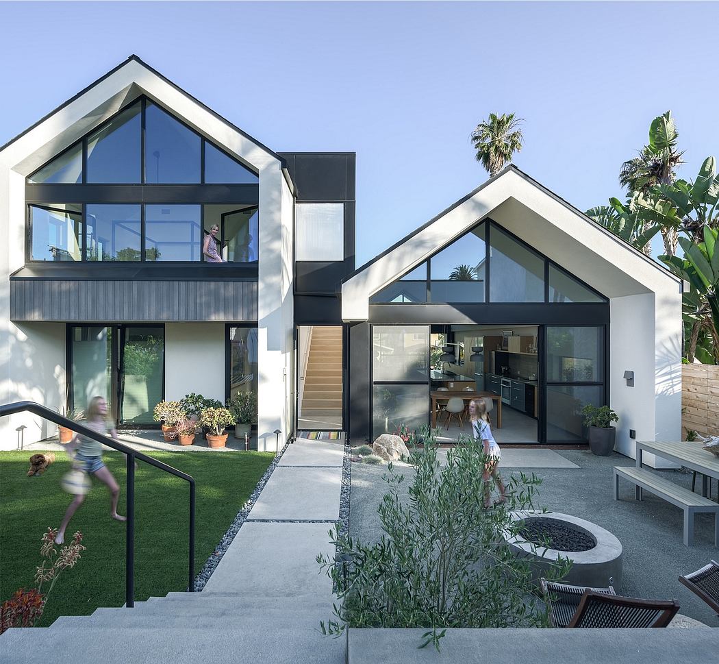 A modern, two-story home with sleek glass walls, an inviting outdoor space, and lush landscaping.