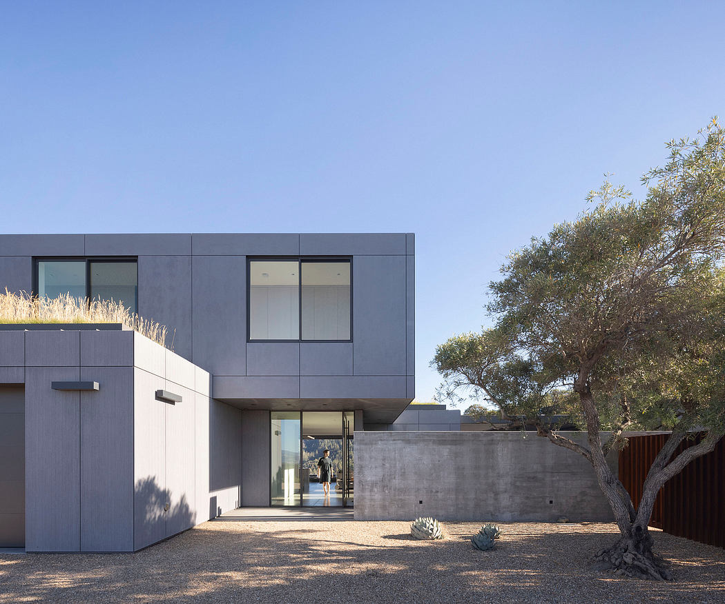 Modern, minimalist architecture featuring clean lines, concrete, and glass elements. Lush landscaping provides a natural backdrop.