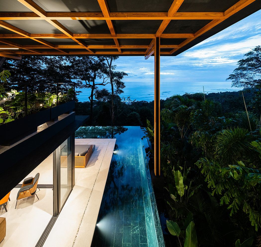 A contemporary outdoor living space with a sleek infinity pool overlooking a lush jungle.