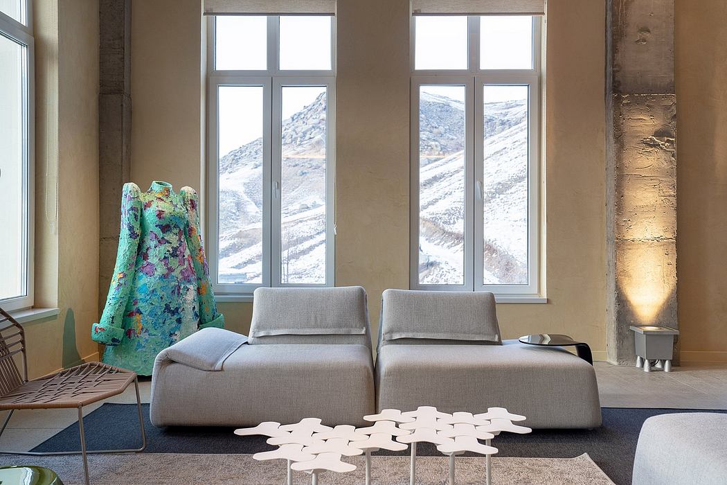 Contemporary living room with large windows, plush gray sofas, and abstract artwork.