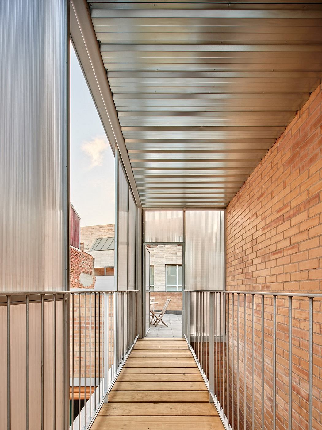 Architectural details showcase a covered walkway with brick walls, metal roofing, and wooden flooring.