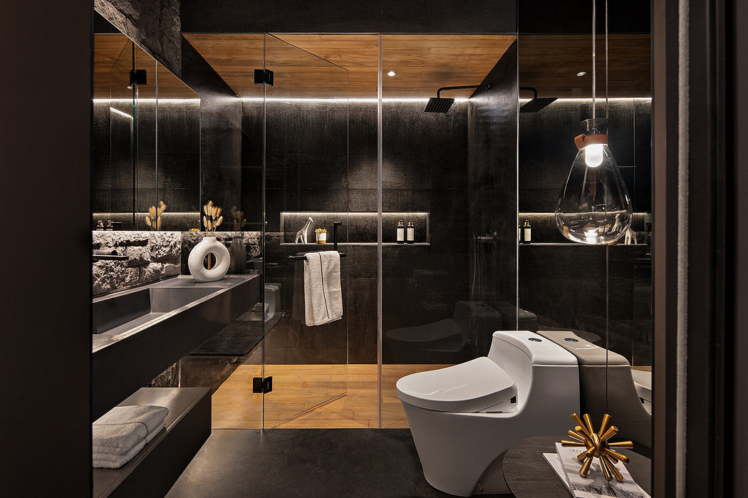 A luxurious bathroom with sleek black marble surfaces, wood accents, and modern lighting fixtures.
